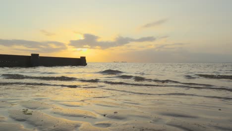 Ship-silhouettes-on-horizon-meeting-on-calm-waters-during-sunset-in-slow-motion-at-Fleetwood,-Lancashire,-UK