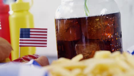 close-up of snacks and cold drink on wooden table