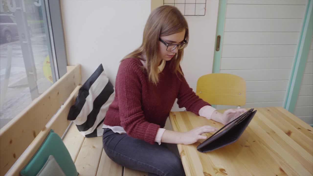 joven usando una tableta en un café