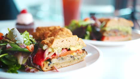 pull focus shot of vegan sandwiches on plate in coffee shop