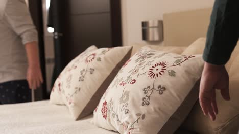 gay couple finishing making bed together in the morning