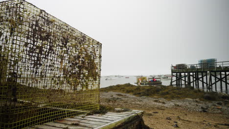 trampa de pesca de langosta en la playa en maine con muelle y puerto deportivo en el fondo 4k 60p