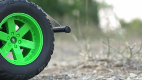 close up on front wheels of rc monster truck, moving back and forth on soil ground 120fps