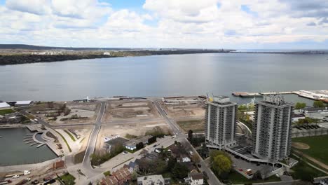 Drone-flying-around-construction-site-by-the-water-in-Hamilton