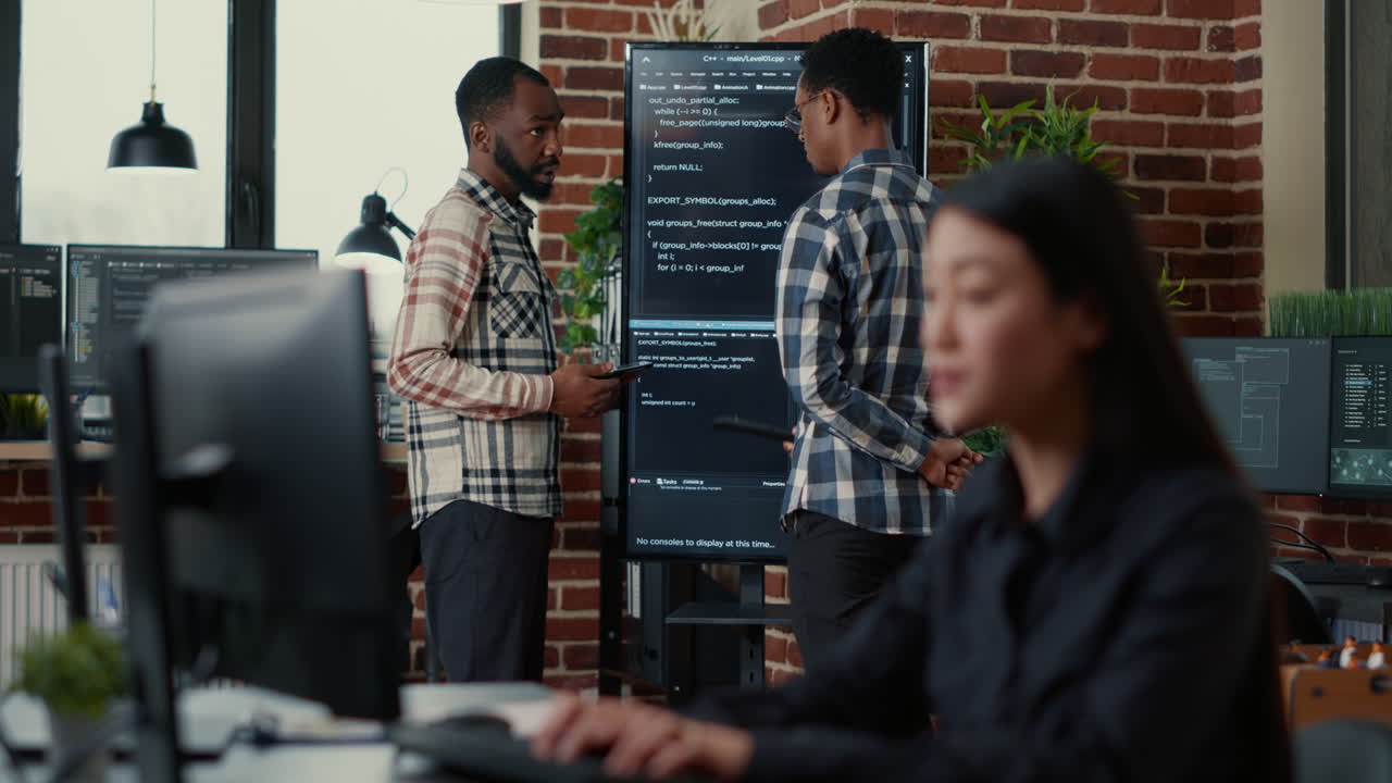 Programmers leaving after analyzing source code on wall screen tv comparing errors using digital tablet
