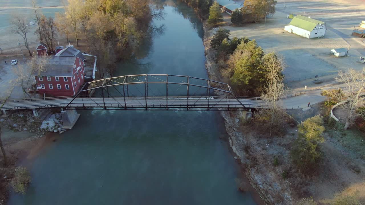 vista aérea del molino grist por el río atravesado por un viejo puente de hierro