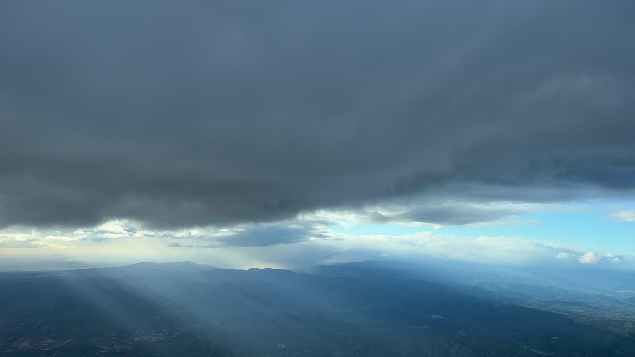 punto de vista del piloto desde la cabina de un jet mientras vuela bajo una capa gris de estratos, en españa, a 6000 m de altura