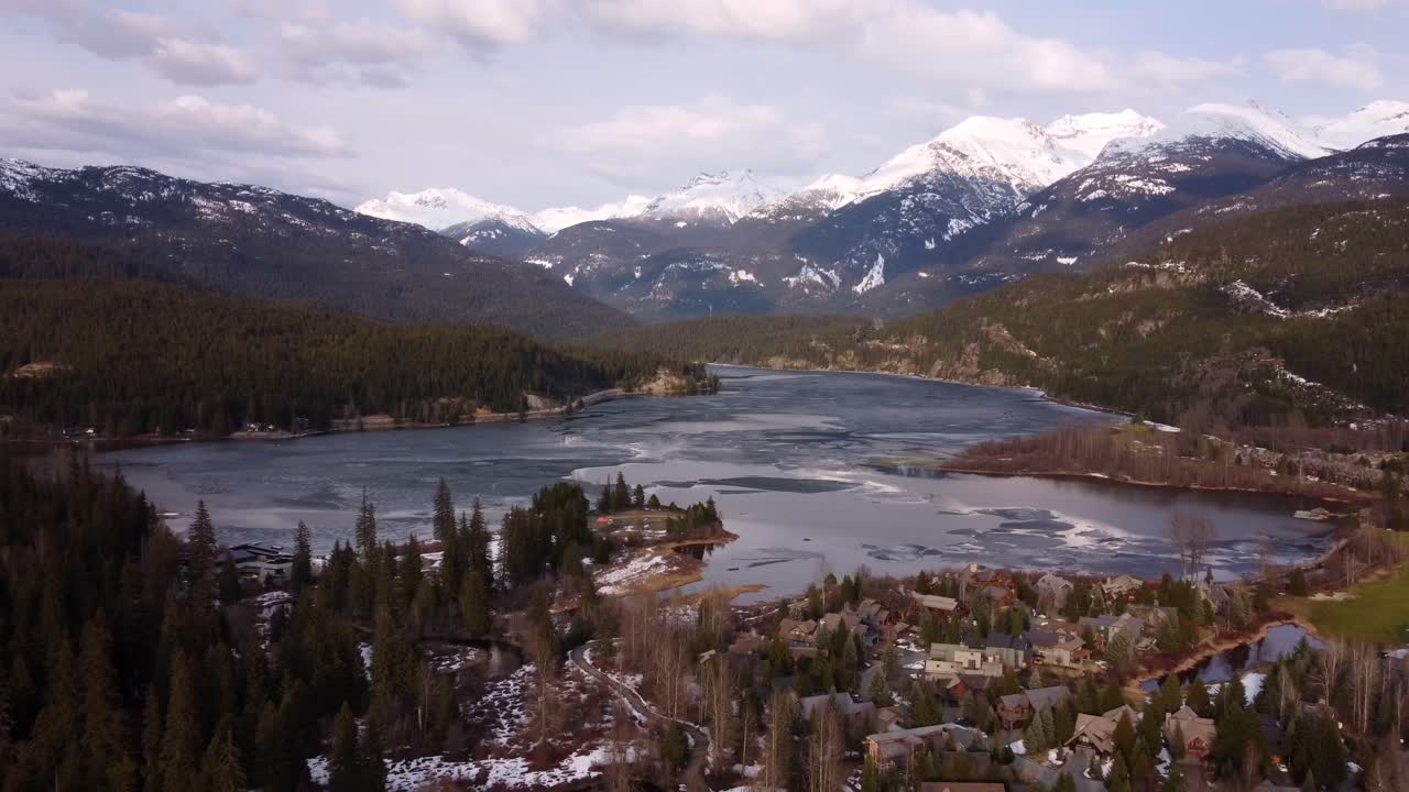 Aerial drone shot Green Lake and snowy mountains in Whistler, Canada