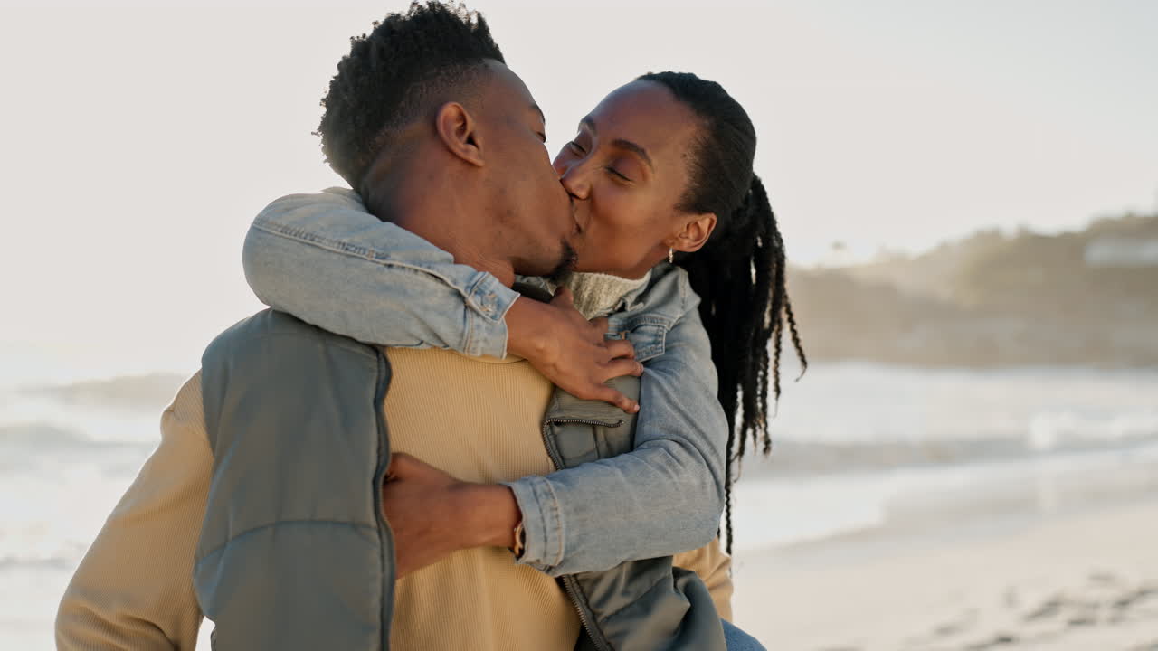 Kiss, happy and black couple at the beach with hug