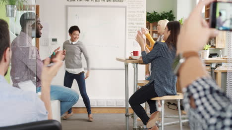 crazy happy asian business woman dancing doing victory dance in team meeting celebrating success achievement