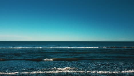 rising shot of the sea waves on a sunny day - aerial view