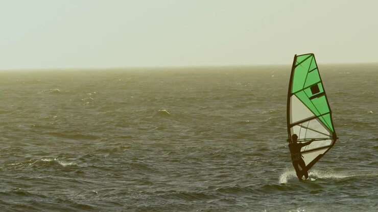 Mandlig surfer windsurfer ved stranden 4k