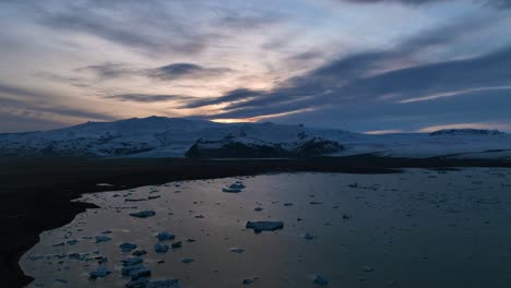 Luftzeitraffer-Des-Wunderschönen-Isländischen-Sonnenuntergangs-über-Der-Landschaft-Des-Eisigen-Sees-Jokulsarlon