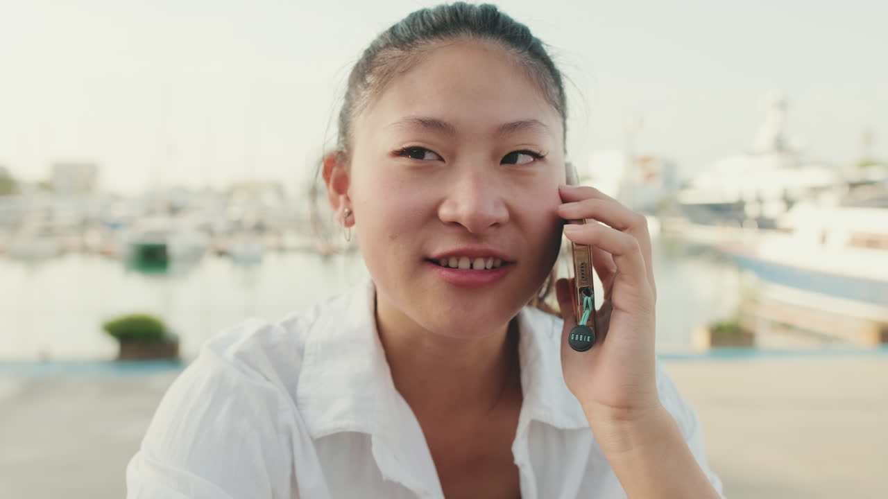マリーナで電話をするアジア人女性