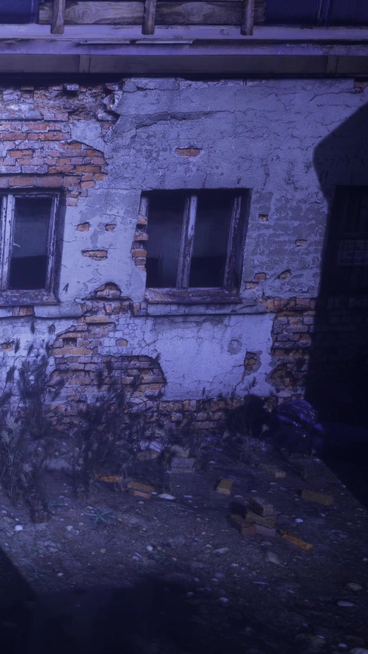 Vecchio edificio con muri danneggiati e ombra di notte.