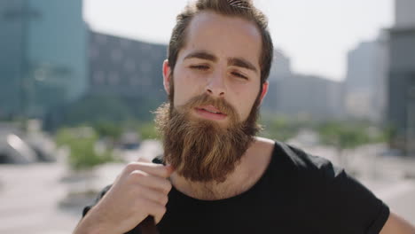 Retrato-En-Cámara-Lenta-De-Un-Lindo-Joven-Y-Confiado-Estudiante-Hipster-Con-Barba-Que-Parece-Pensativo-Y-Serio-Ante-La-Cámara-En-Una-Soleada-Ciudad-Urbana