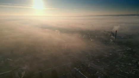 spiritual scene of aerial drone shot above industrial urban townscape areas shrouded in morning mist