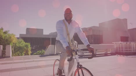 animation of light spots over african american man cycling in city