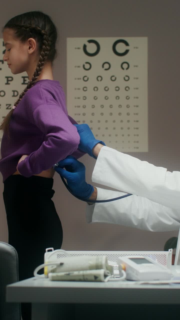 un medico che esamina la schiena di un bambino con uno stetoscopio