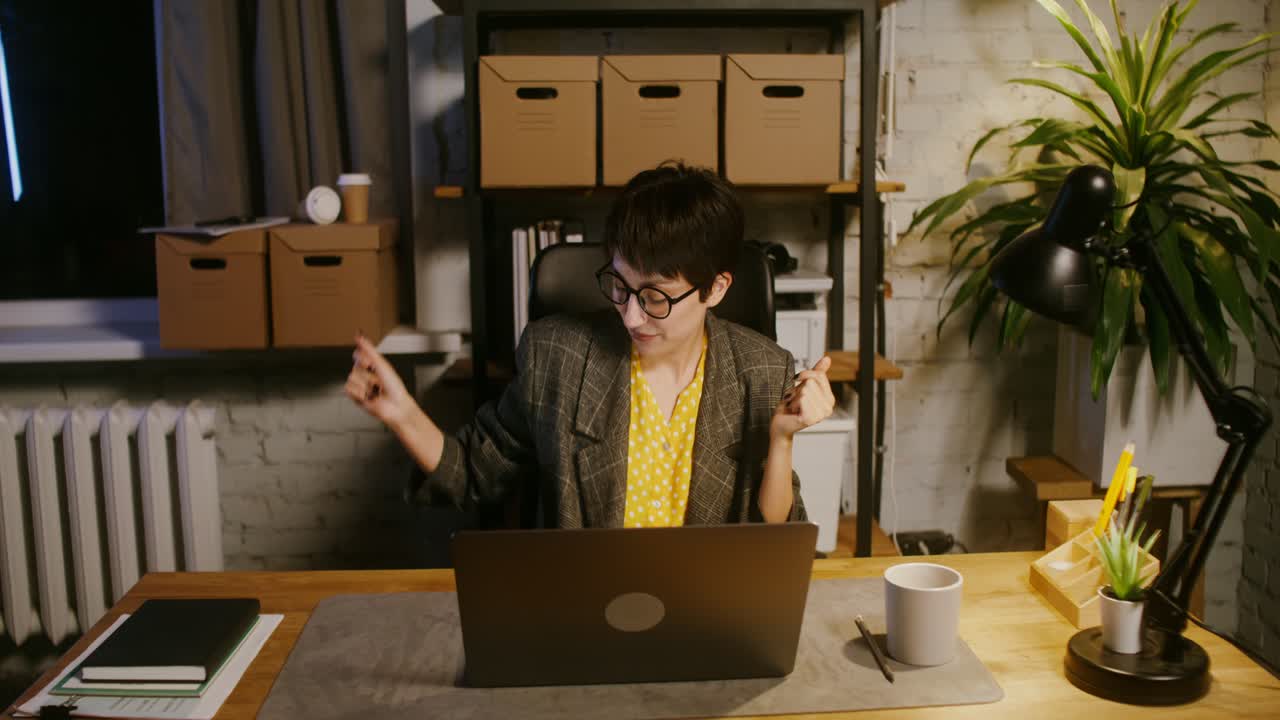 행복 한 여자 는 집 사무실 에서 밤 에 성공 을 축하 하고 있다