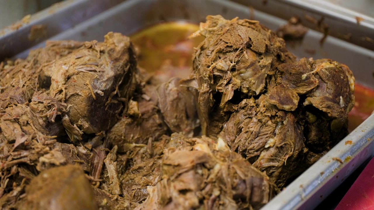 Filmato della cottura della birria che mostra un primo piano della carne di birria durante il tradizionale processo di cottura messicano.