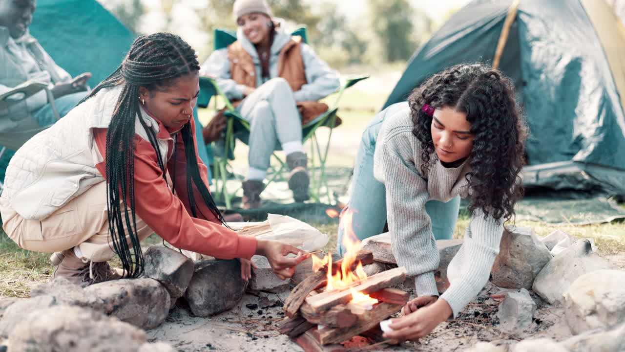 Friends gathering around a campfire while camping