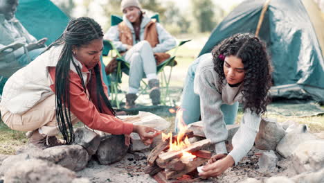friends gathering around a campfire while camping