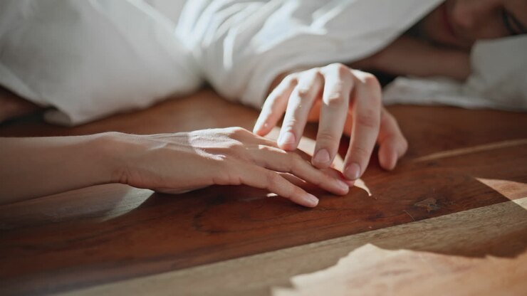 Gros plan sur les mains d’un couple se connectant au soleil. Des personnes affectueuses profitent d’un moment romantique.