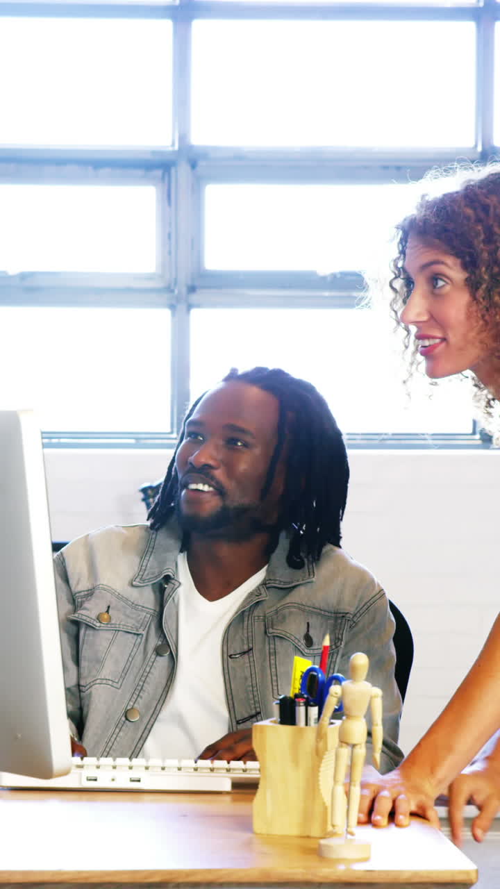 Colleagues looking at computer and discussing with each other