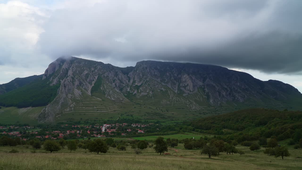 Timelapse av mørke skyer som ruller over de ruvende kalksteinsklippene i Piatra Secuiului-fjellet over landsbyen Torockó i Romania