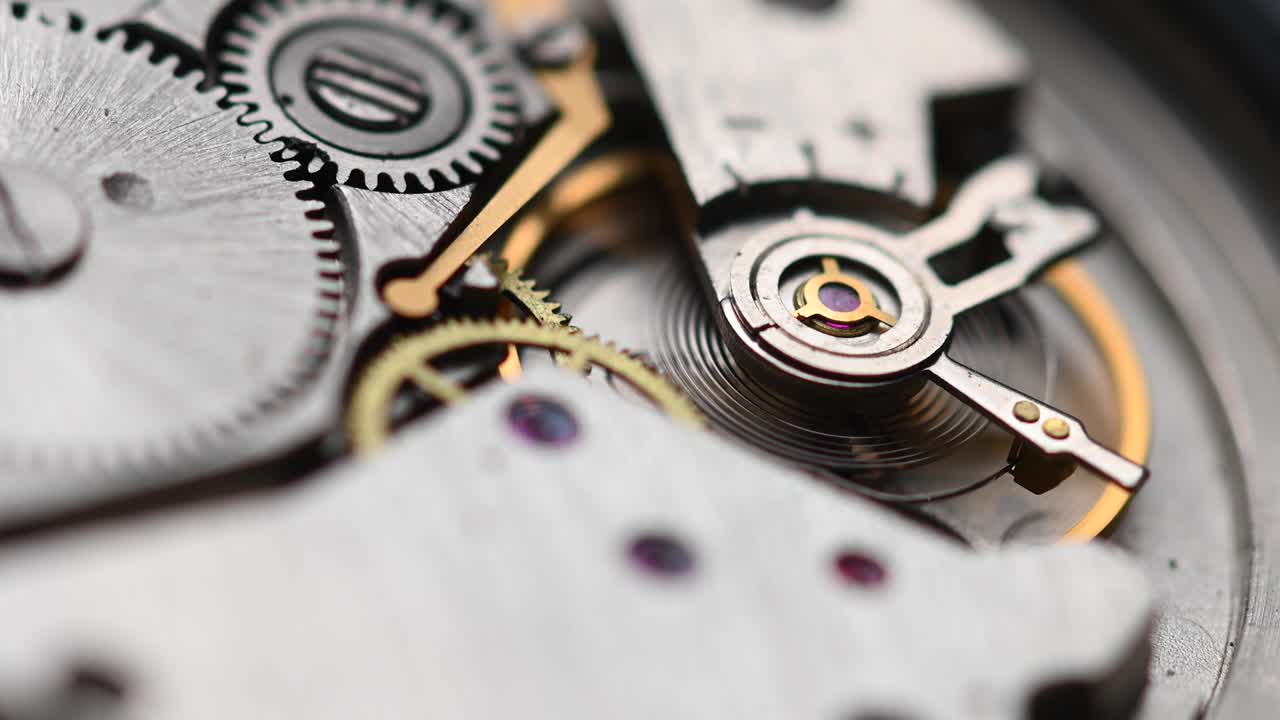 Internal working mechanism of the wristwatch with a rapidly rotating pendulum and gears. 4k clock close up with shallow depth of field