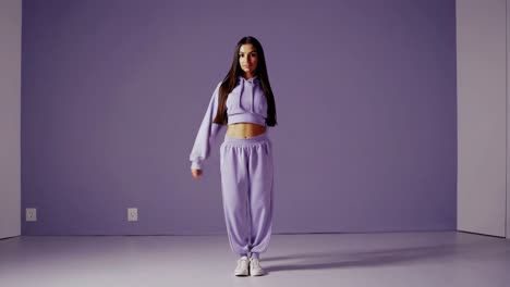 una mujer con ropa de deporte púrpura bailando.