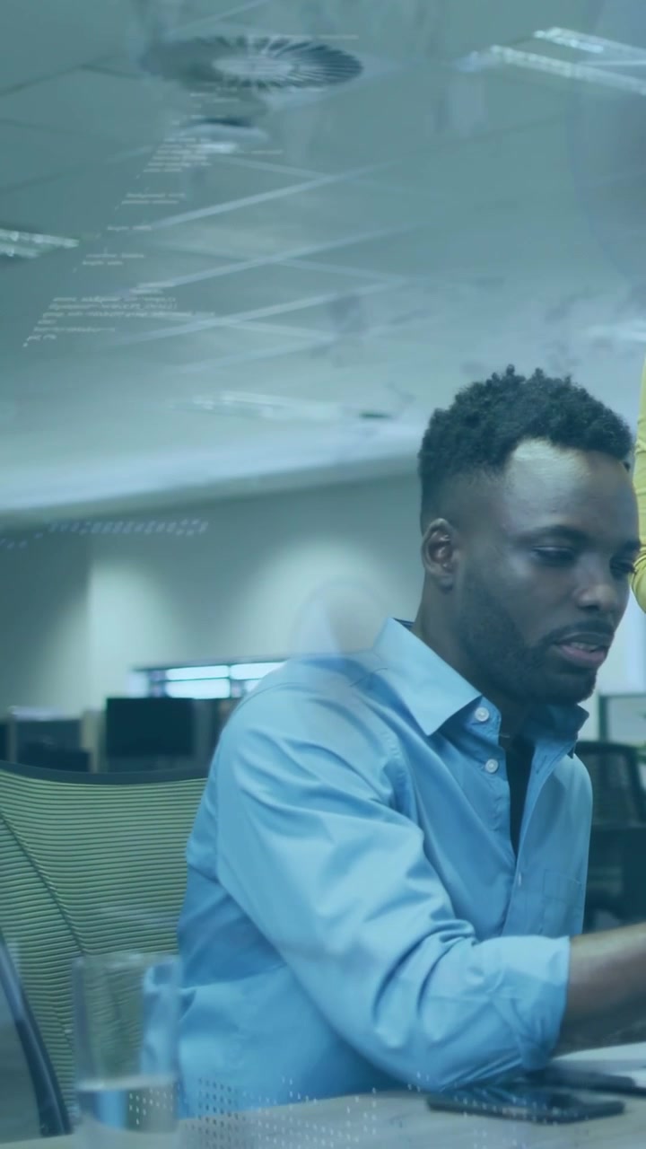 Vertical video: Man typing on laptop after peer prompt, causing chart overlay for business review