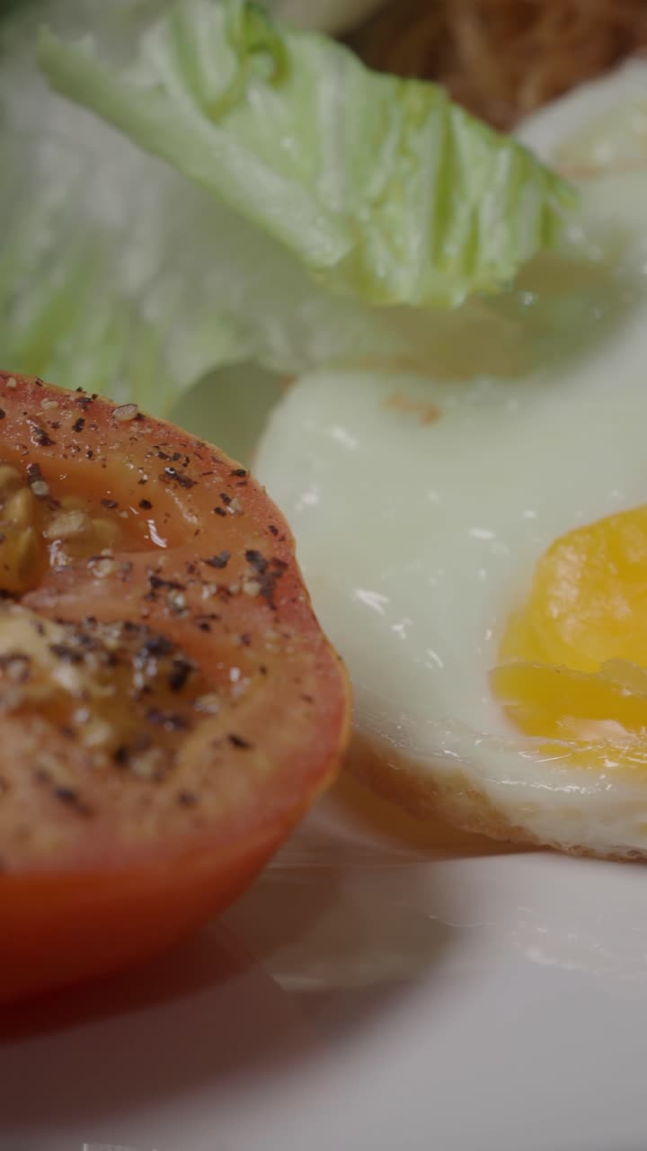 Nærbilde av et speilegg med tomat og salat