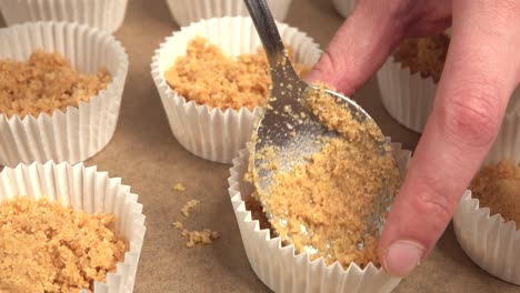 aplanar y acomodar la base de galleta en molde para hacer cupcakes