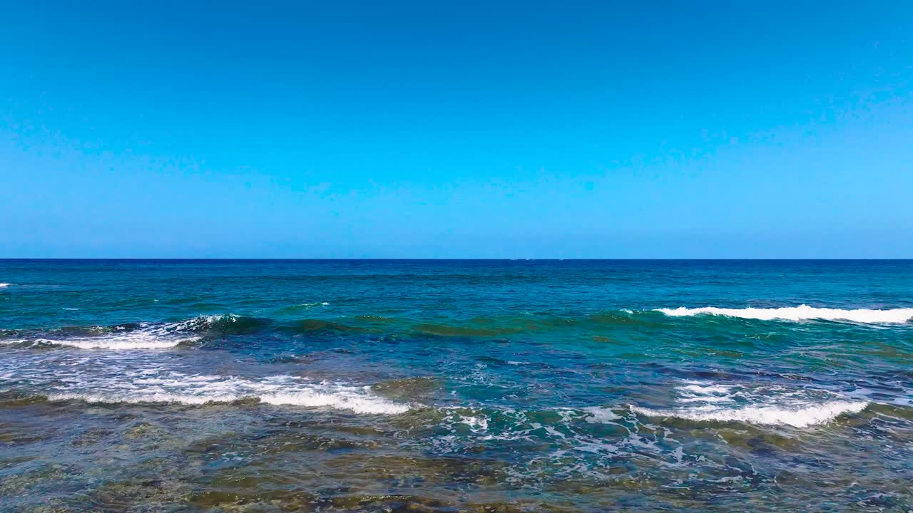 View of volcanic rocks and clear blue water at a beach in the Canary Islands