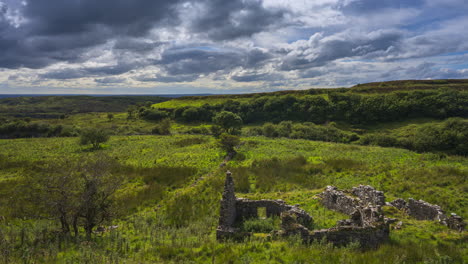 timelapse de paisaje de naturaleza rural con ruinas de viejas casas de piedra abandonadas en primer plano durante un día soleado y nublado visto desde carrowkeel en el condado de sligo en irlanda