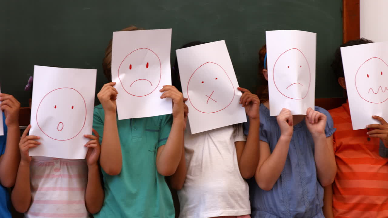 얼굴이 있는 페이지를 들고 있는 학생들