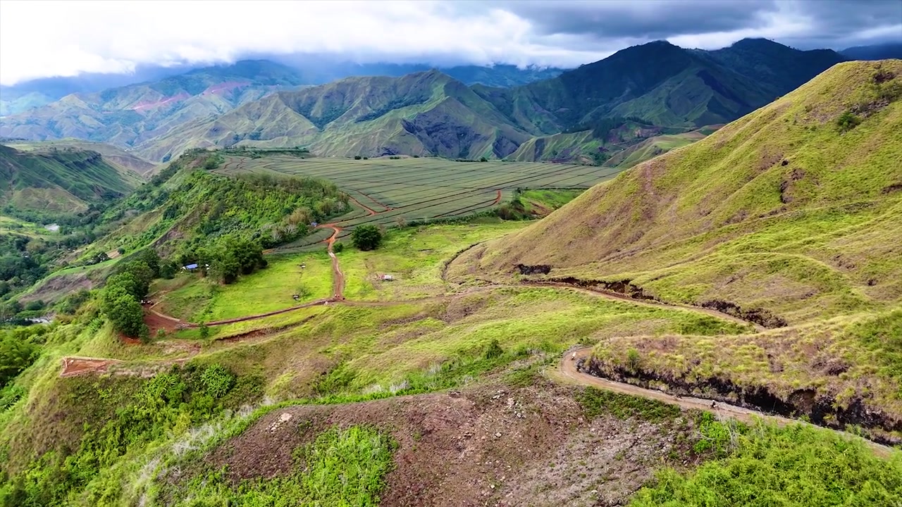 Pengendara Motor Menuruni Gunung dengan Latar Belakang Pegunungan