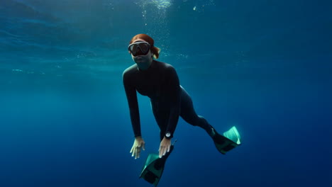 freediver gliding through clear blue ocean water