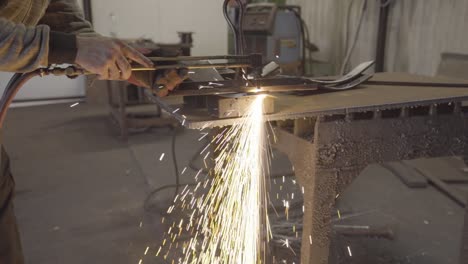 cutting a thick steel plate with handheld plasma cutter. amazing spark shower in the workshop