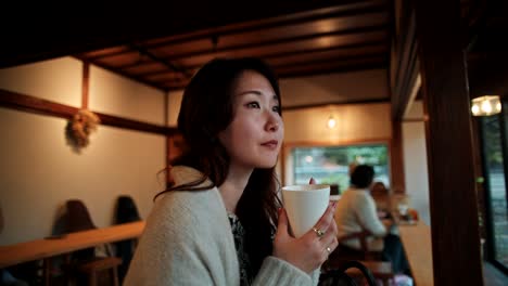 Woman enjoying a drink in a cozy Japanese cafe