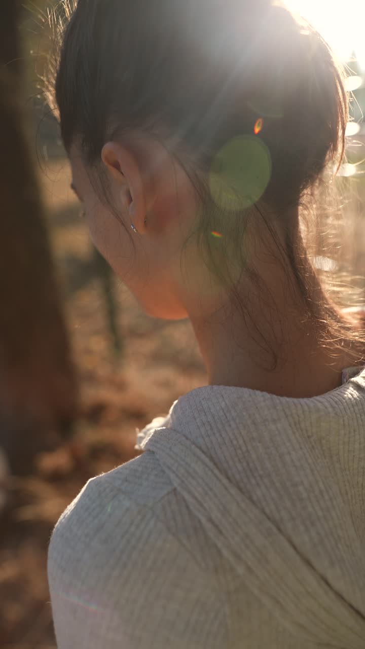 mujer en un parque a la luz del sol de otoño