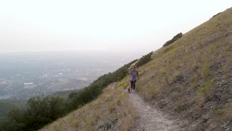 Kaukasische-Frau-Und-Gekritzelwelpe,-Die-Auf-Wanderweg-In-Den-Utah-bergen-Gehen