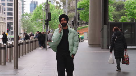 indian punjabi man walking while talking on the phone