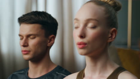 portrait calm meditating couple with closed eyes close up. pair practicing yoga.