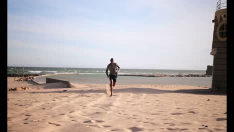 african american male runner jogging on beach in the sunshine 4k