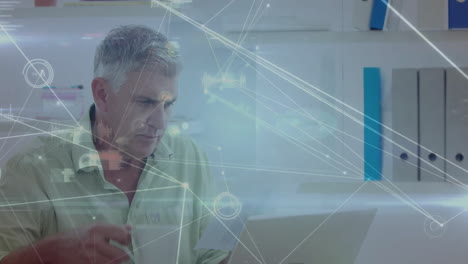 animación de la red y el procesamiento de datos sobre el hombre caucásico senior usando computadora portátil en la oficina casual