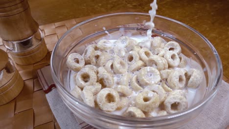 crispy oat flakes in a bowl for a morning delicious breakfast with milk. slow motion with rotation tracking shot.