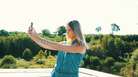 Mujer-Feliz-Sonriendo-Y-Tomando-Selfie-Con-Un-Teléfono-En-Cámara-Lenta